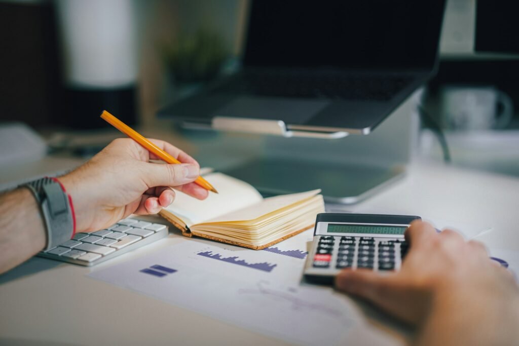 Bookkeeper reconciling accounts with a calculator and notebook
