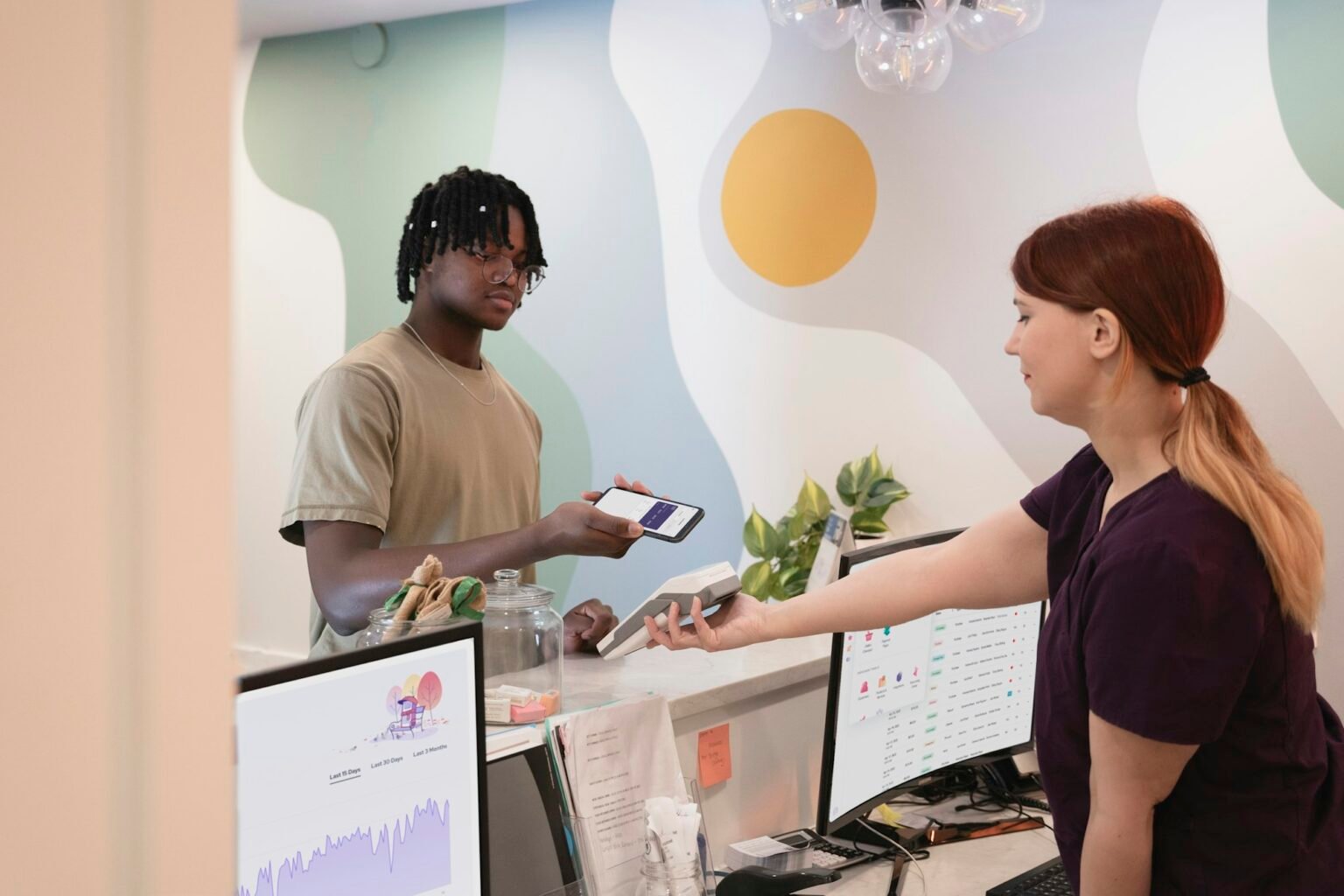 Patient paying at a wellness clinic front desk, the kind of cash-pay transaction our bookkeeping and payroll services keep organized