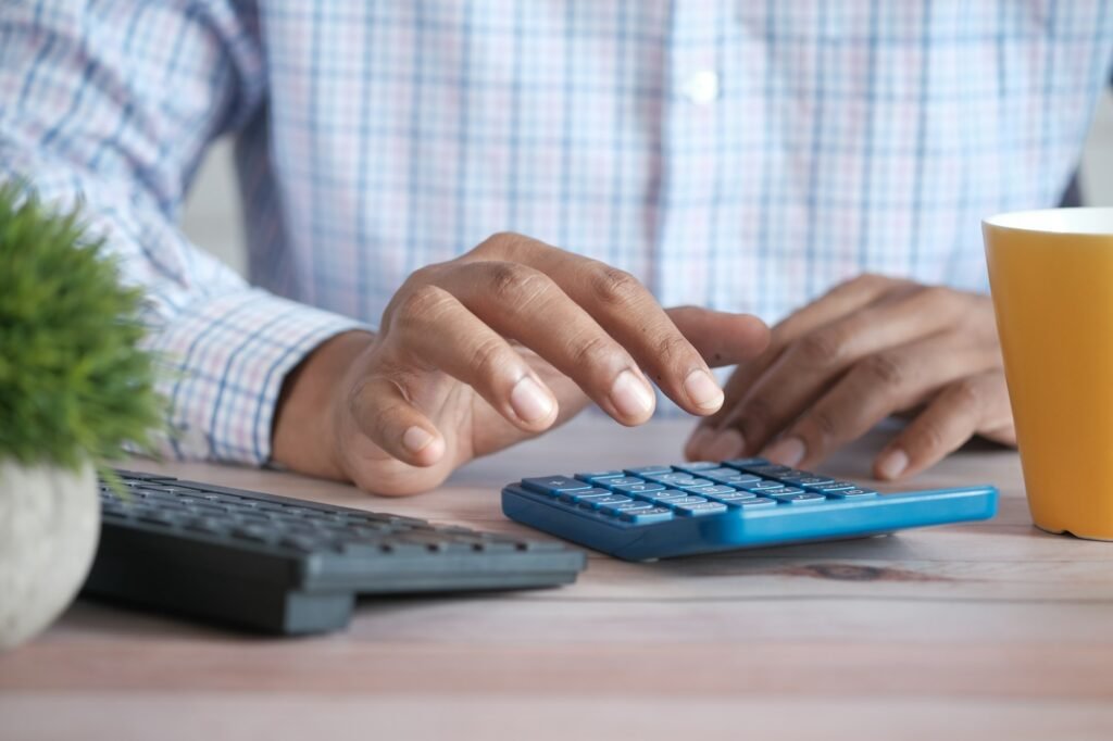Practice owner reviewing monthly bookkeeping with a calculator