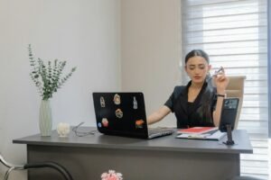 Practice owner working at a desk with a laptop and phone